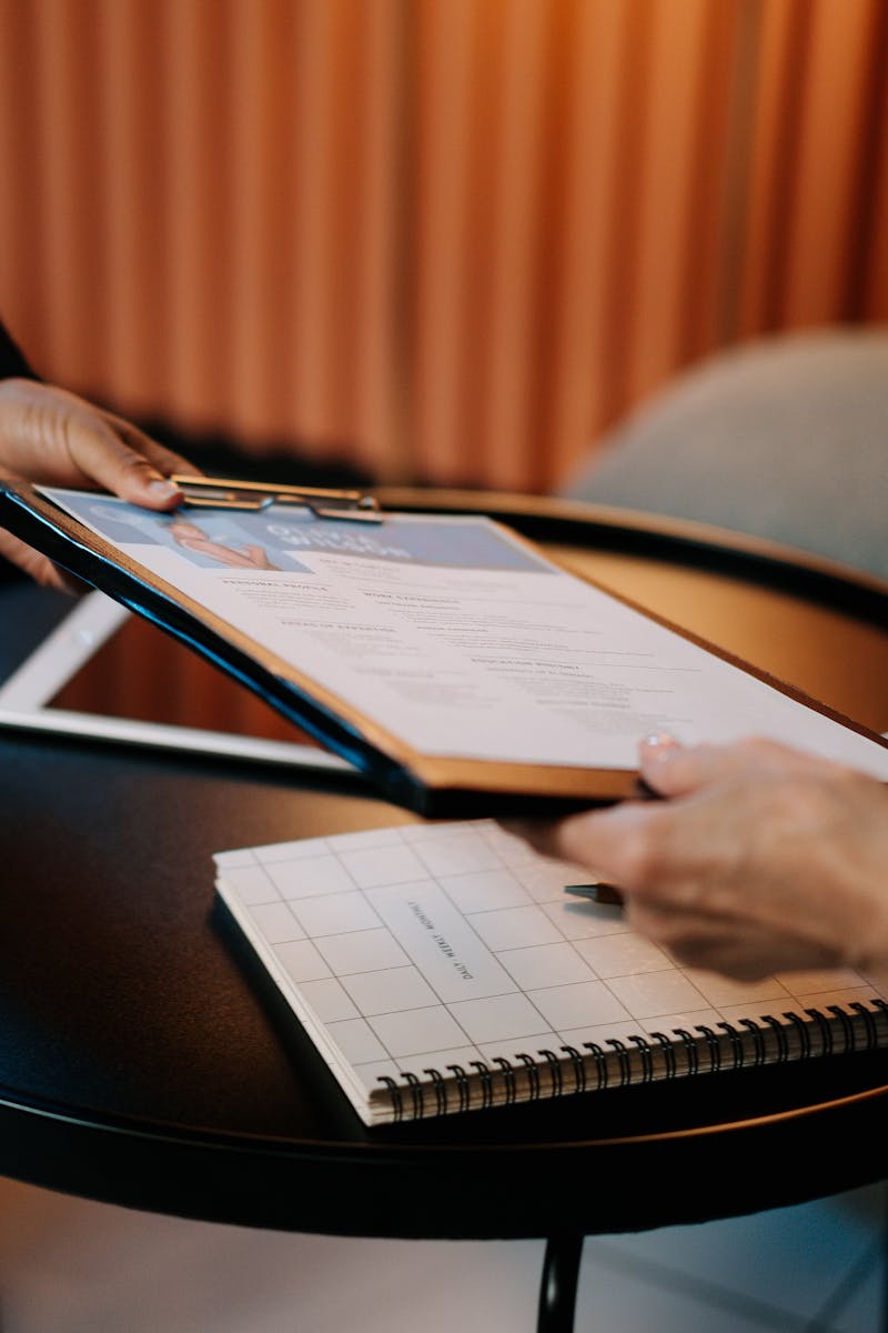 Business professionals exchanging resume during meeting, focusing on career advancement.